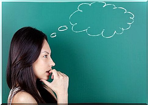 woman thinking in front of blackboard