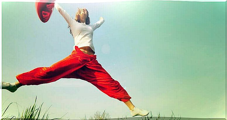 Happy woman jumping with balloon