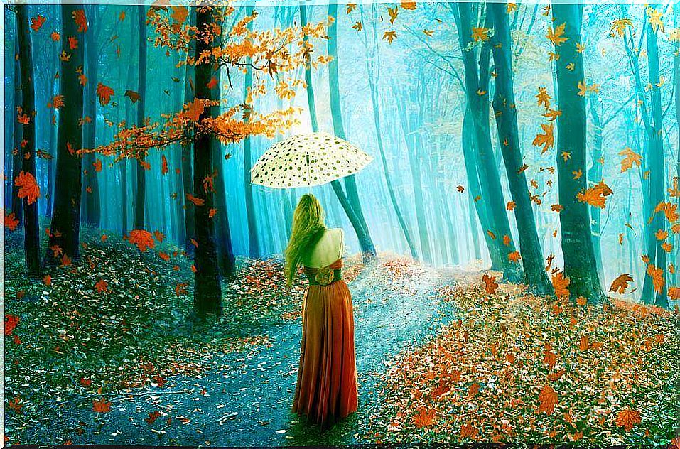 Woman walking in forest in autumn.