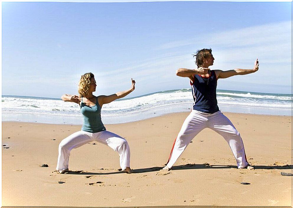 couple practicing qi gong on the beach