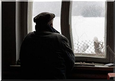 man watching snow through the window