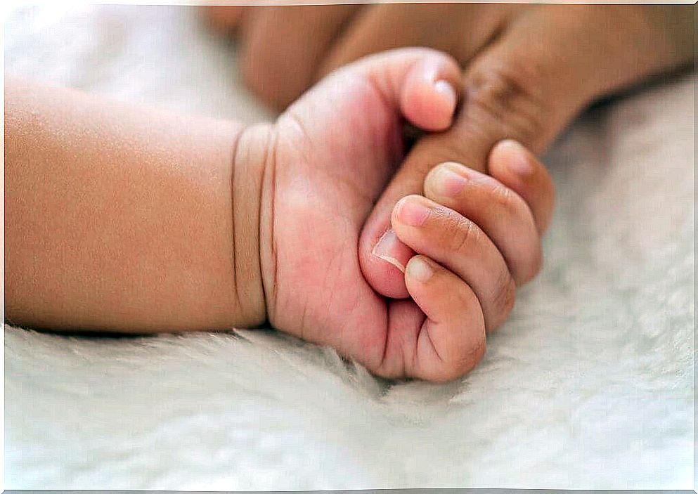 baby taking mother's finger