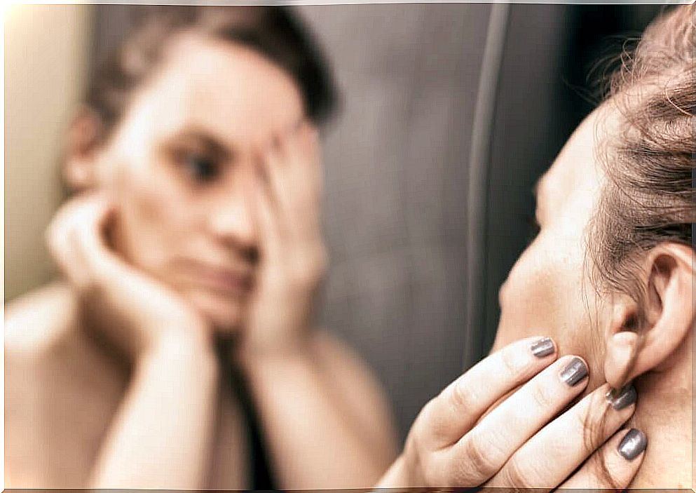 Woman sad with what she sees in the mirror